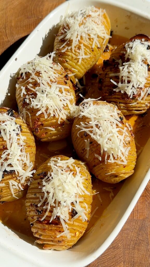 Remove the potatoes from the oven and sprinkle freshly grated Parmesan over the tops