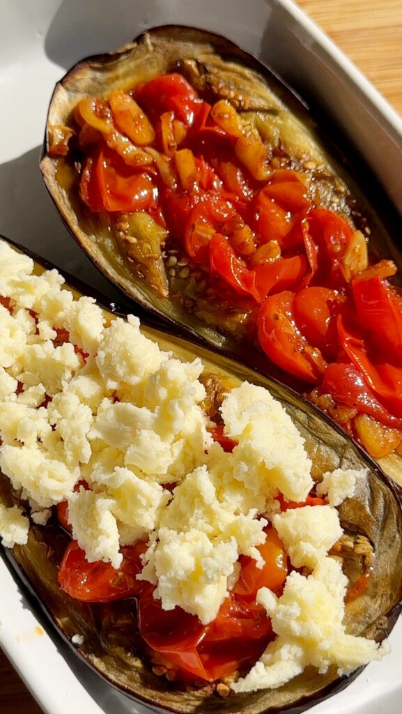 Spoon the tomato mixture over the eggplant halves and top with torn mozzarella pieces.