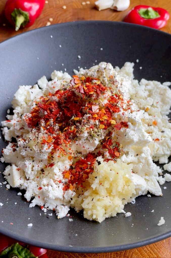 Make the Filling
In a bowl, crumble the feta cheese with a fork.
Mix in 2 tablespoons of olive oil, garlic, oregano, black pepper, and chili flakes.