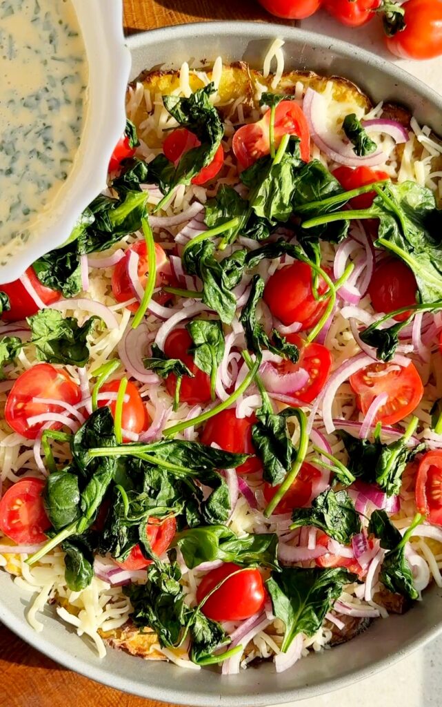 Spread mozzarella, cherry tomatoes, red onion, and wilted spinach over the baked potato crust.