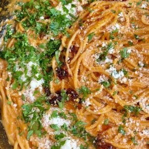 One-pot creamy tomato pasta garnished with chili oil, extra Parmesan, and fresh parsley, ready to serve.